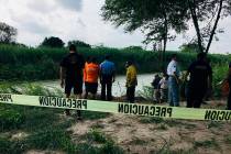 Authorities stand behind yellow warning tape along the Rio Grande bank where the bodies of Salv ...