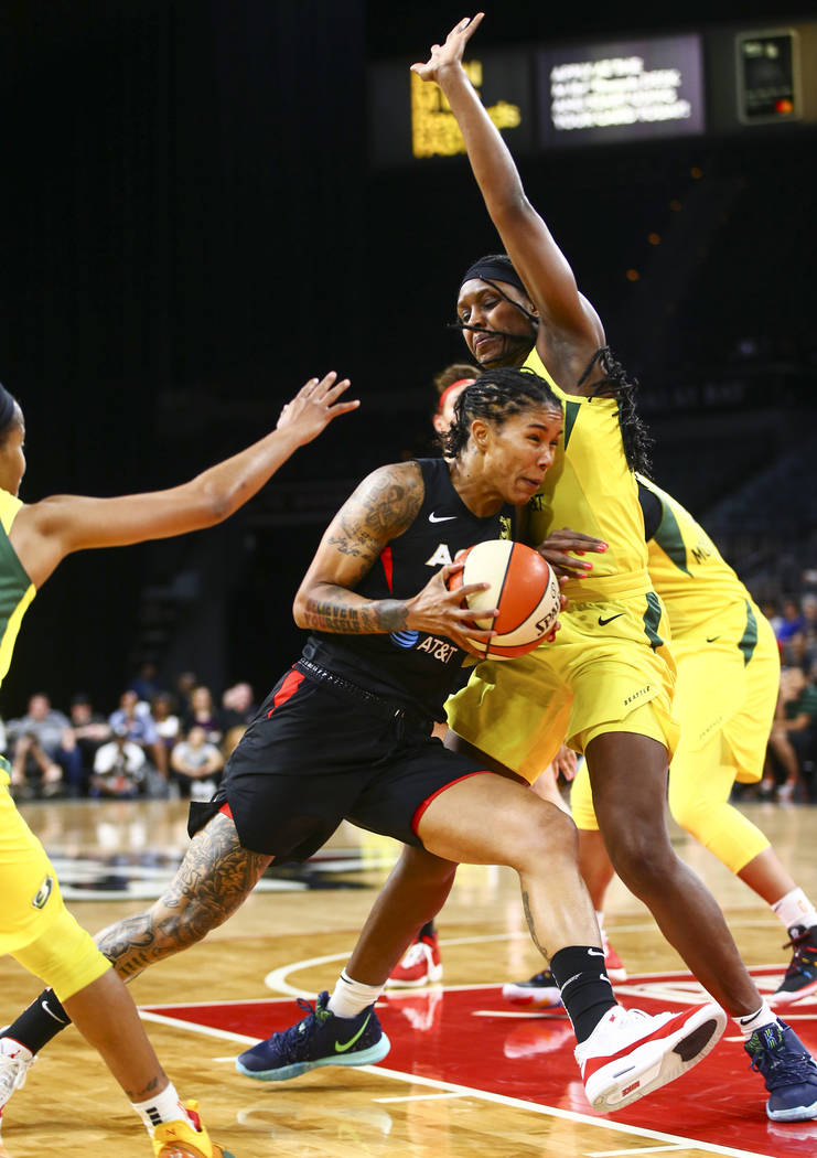 Las Vegas Aces forward Tamera Young, left, drives to the basket against Seattle Storm forward C ...
