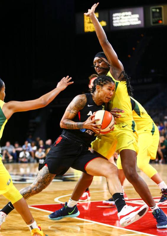 Las Vegas Aces forward Tamera Young, left, drives to the basket against Seattle Storm forward C ...