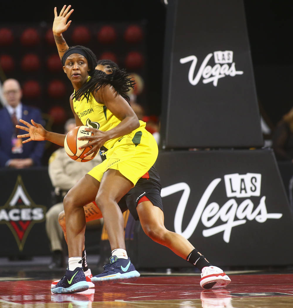 Seattle Storm forward Crystal Langhorne moves the ball around a Las Vegas Aces defender during ...