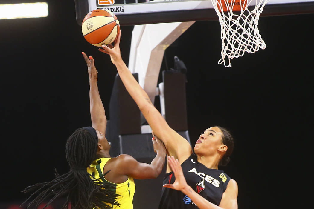 Las Vegas Aces center Liz Cambage, right, blocks a shot from Seattle Storm forward Crystal Lang ...