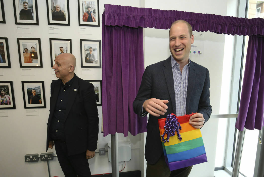 Britain's Prince William, the Duke of Cambridge, reacts to receiving a gift bag from trust chie ...