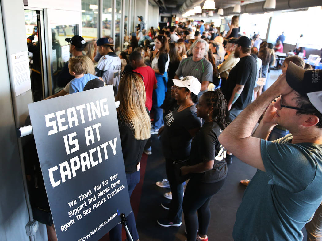 Fans watch the Vegas Golden Knights practice from a hallway after seating was at maximum capaci ...