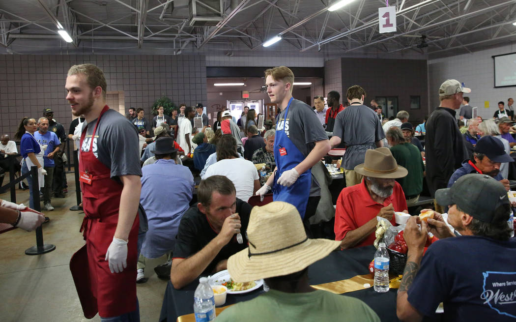 Vegas Golden Knights Development Camp participants prepare to serve a meal to clients as they p ...