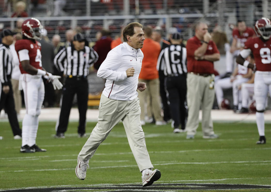 Alabama head coach Nick Saban runs across the field during warm ups before the NCAA college foo ...