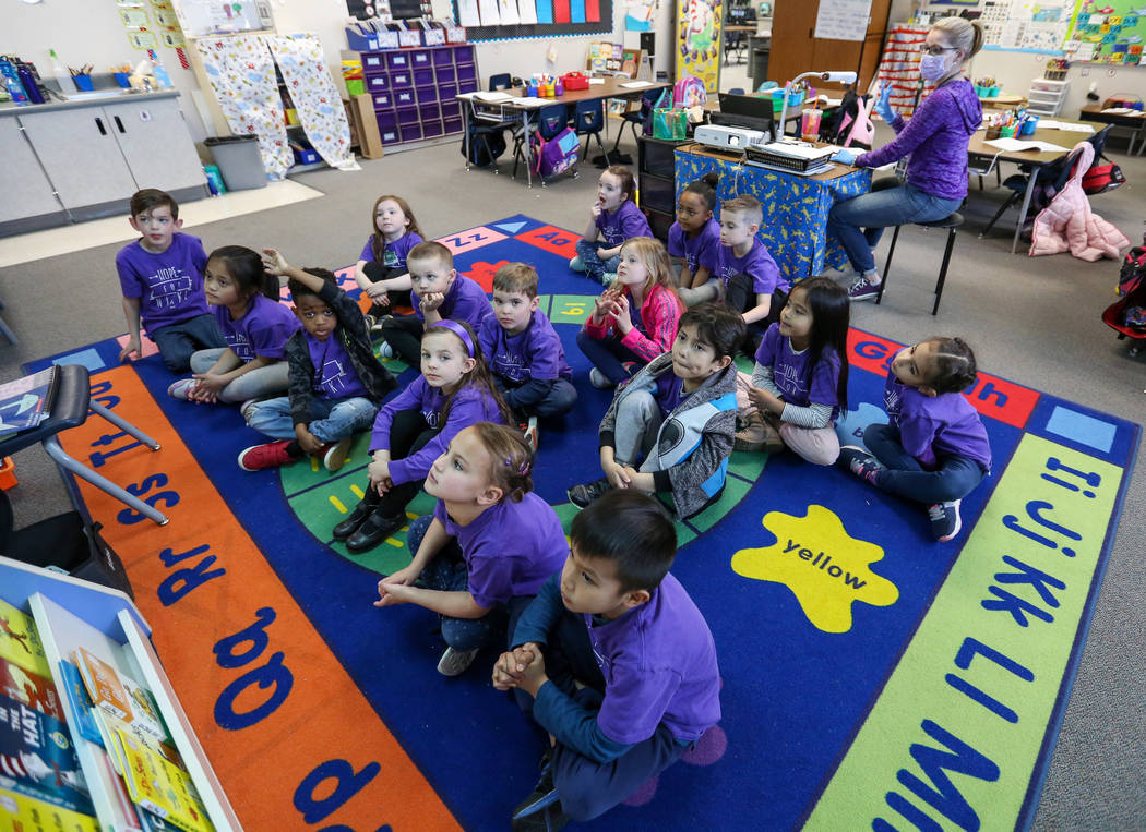 Kindergarten students watch images projecting on the screen as their teacher Nikki McGuire, bac ...