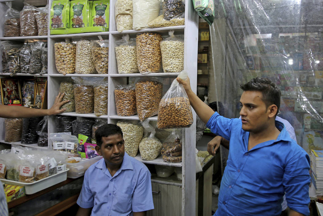 In this Saturday, June 22, 2019 photo, a salesman holds a bag of California almond kernels for ...