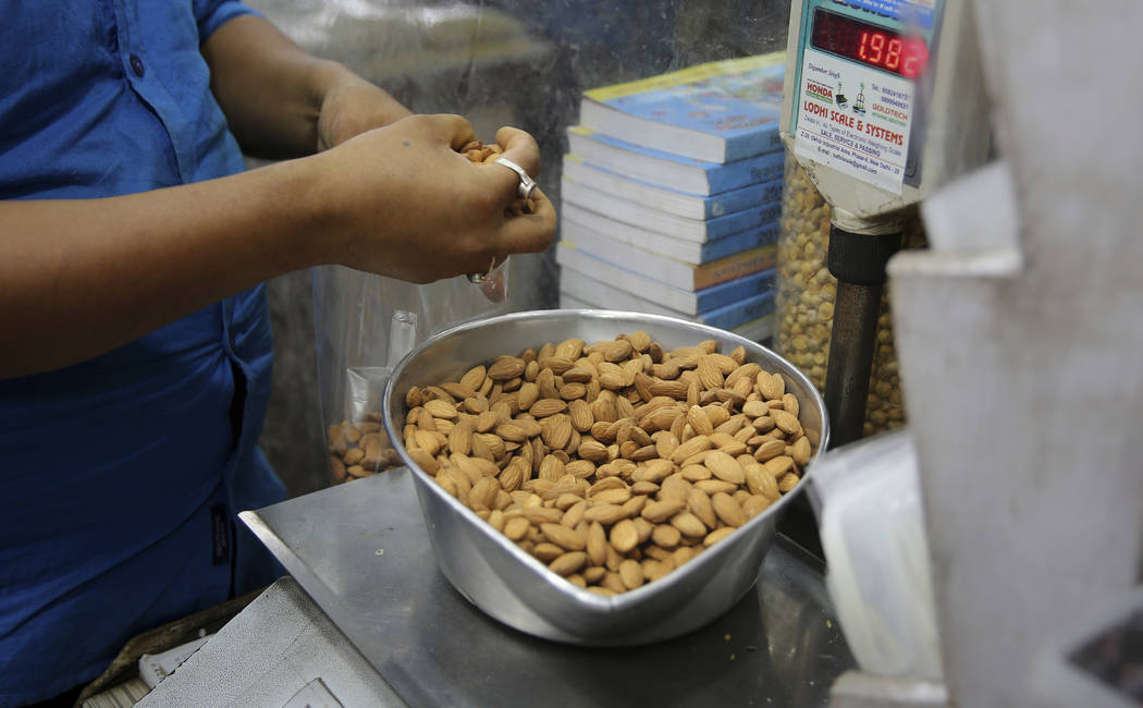 In this Saturday, June 22, 2019 photo, a shopkeeper weighs California almonds for a customer at ...