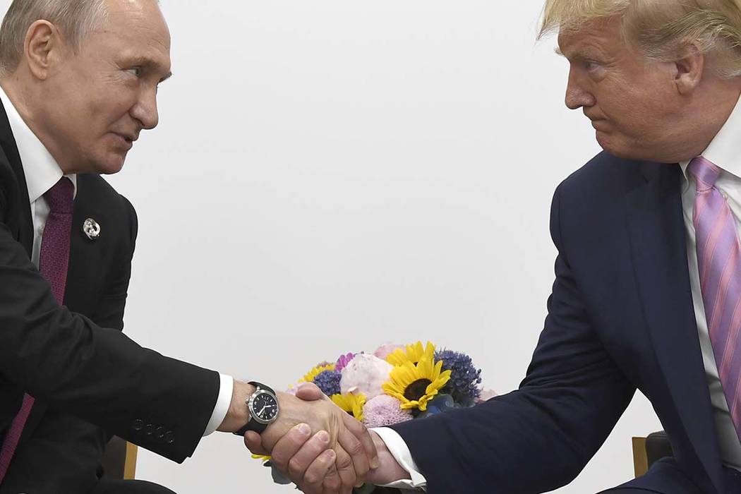 President Donald Trump, right, shakes hands with Russian President Vladimir Putin during a bila ...