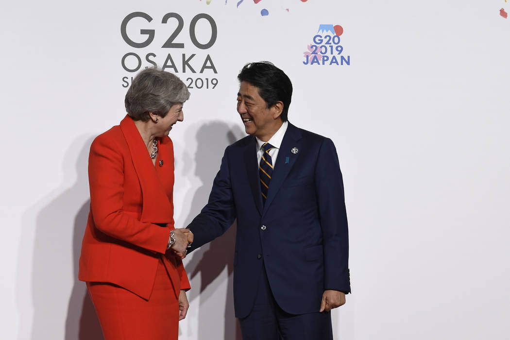 British Prime Minister Theresa May, left, shakes hands with Japanese Prime Minister Shinzo Abe, ...