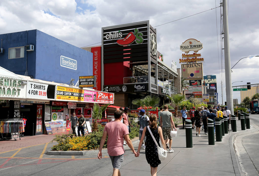 People walk on the Strip near Harmon Avenue past a 16-acre piece of property that includes the ...