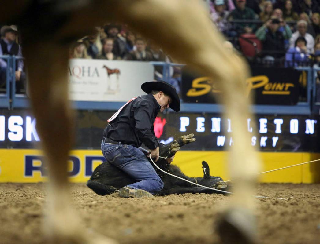 Trevor Brazile of Decatur, Texas (2) competes in tie-down roping during the tenth go-round of t ...