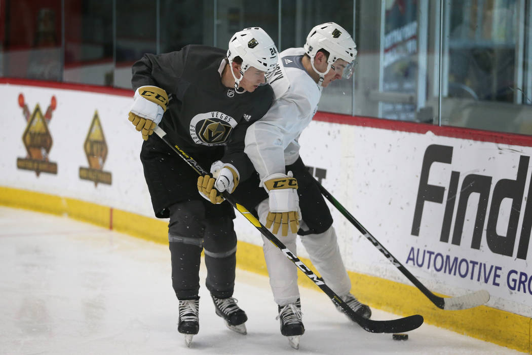 Vegas Golden Knights' Garrett Pinoniemi, left, looks to make a play under pressure from Mike Vo ...