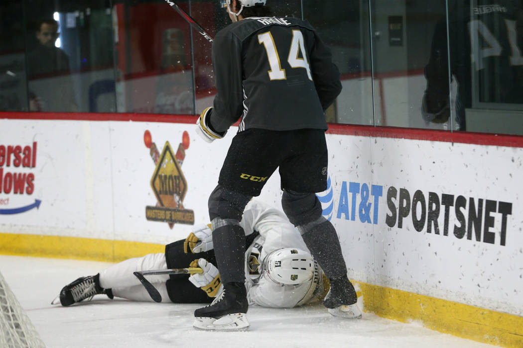 Vegas Golden Knights' Nicolas Hague (14) stands over Jack Dugan (51) after he took a fall durin ...