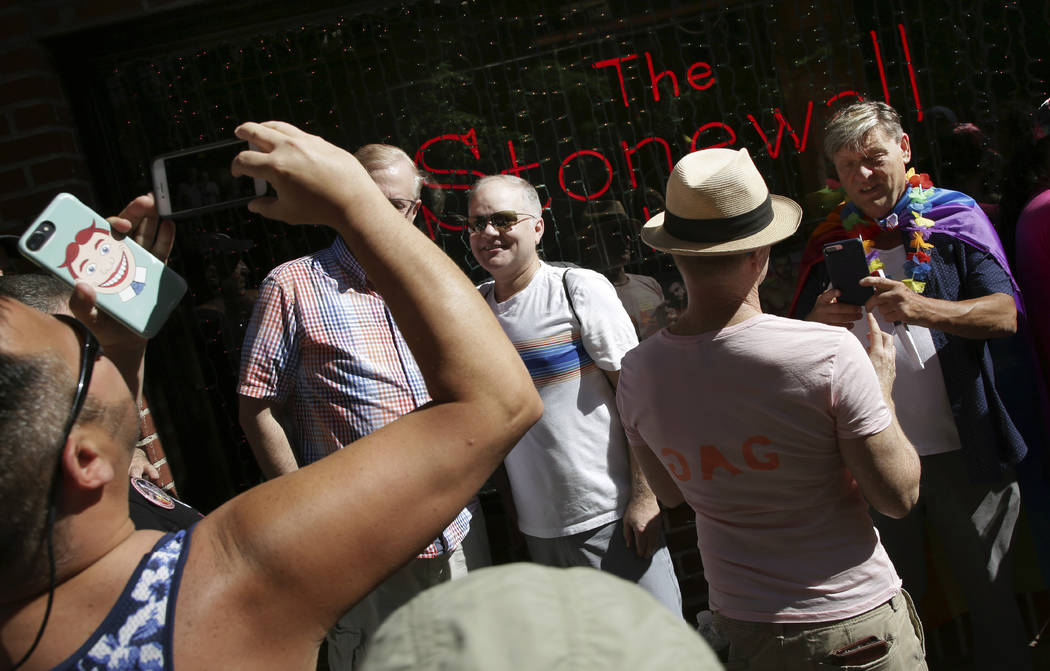 People pose for pictures in front of the Stonewall Inn before the start of the Queer Liberation ...