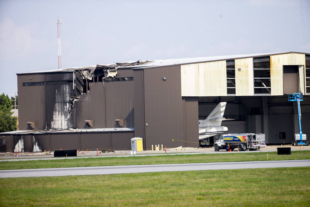 Damage is seen to a hangar after a twin-engine plane crashed into the building at Addison Airpo ...