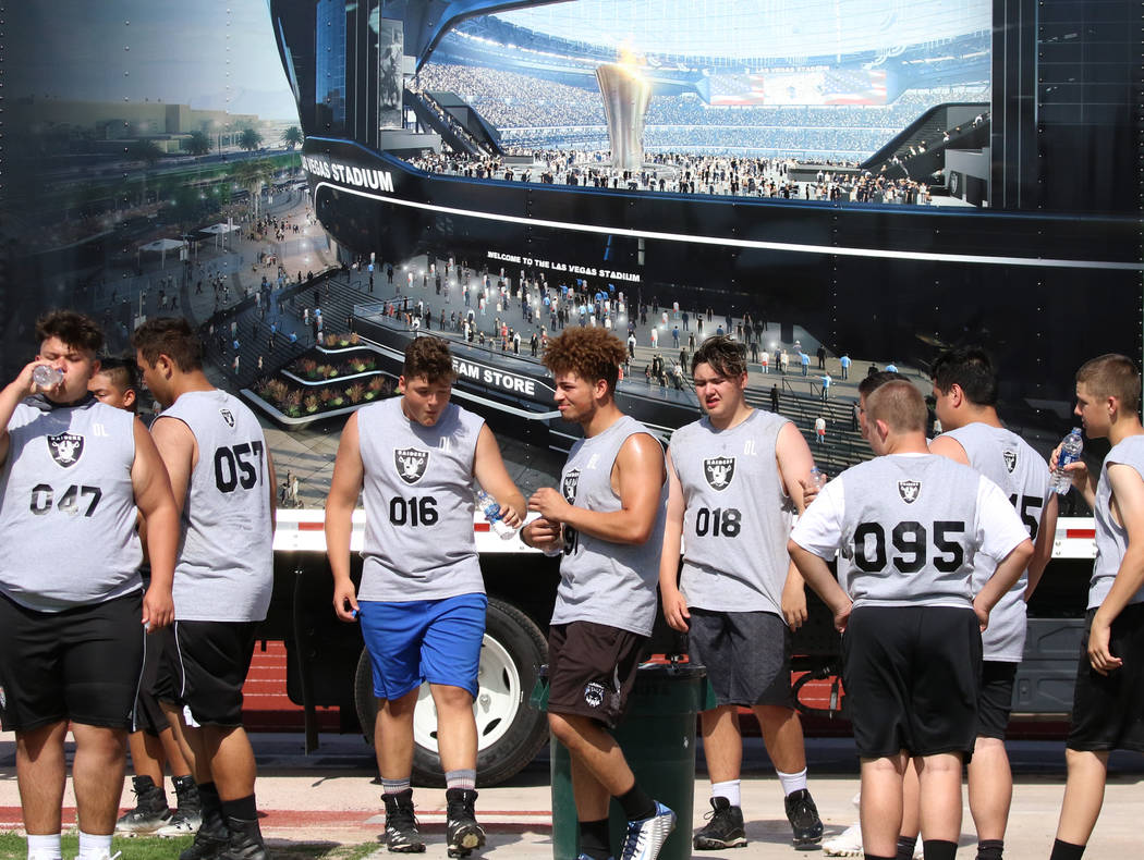 Local Clark County-area high school football players take a break as they participate in fun ...