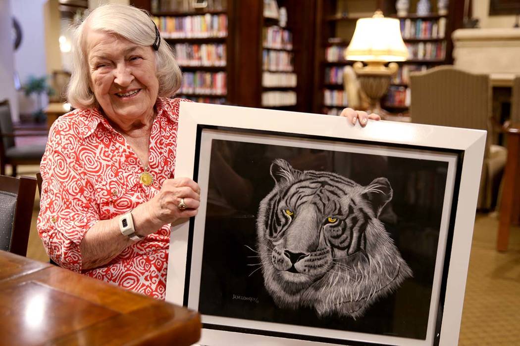 Artist Hannelore Lowrey shows one of her pieces in the library of her living facility Wednesday ...