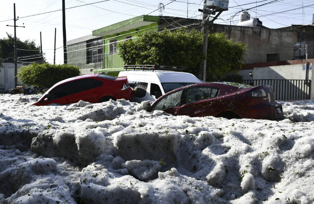 In this photo released by Jalisco State Civil Defense Agency, cars are suspended in hail in Gua ...