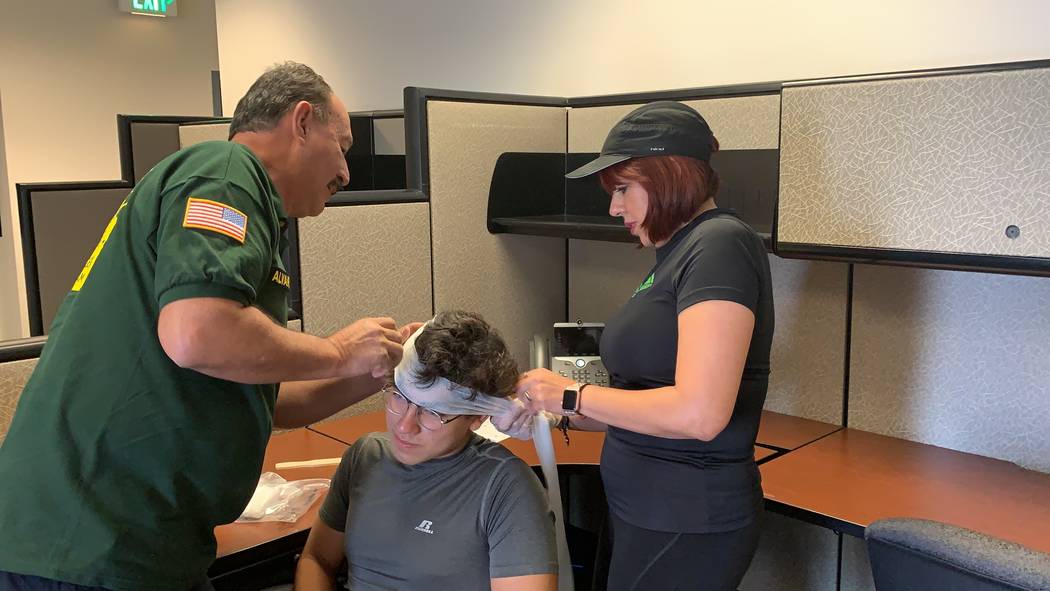 Silvia Romero, right, helps bandage the head of an attendee at the CERT training class on Satur ...