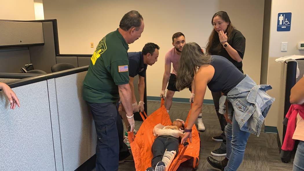 Attendees of the CERT training course learn to carefully lift an injured victim. The training c ...
