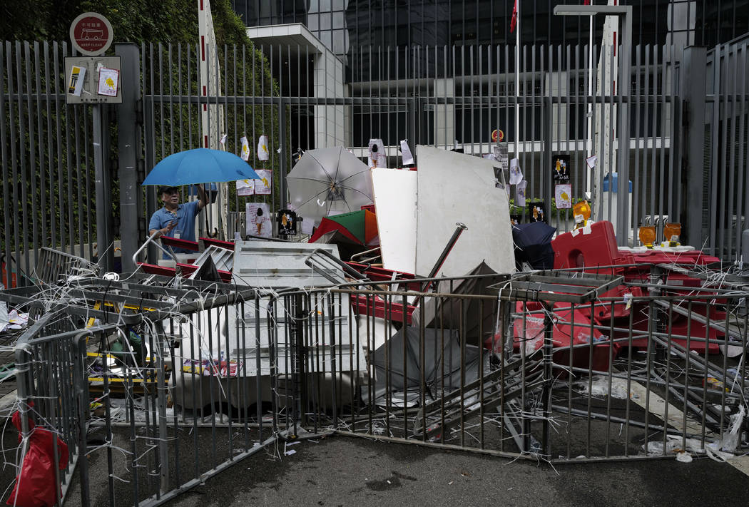 A worker cleans up the main entrance outside government headquarters in Hong Kong, Tuesday, Jul ...