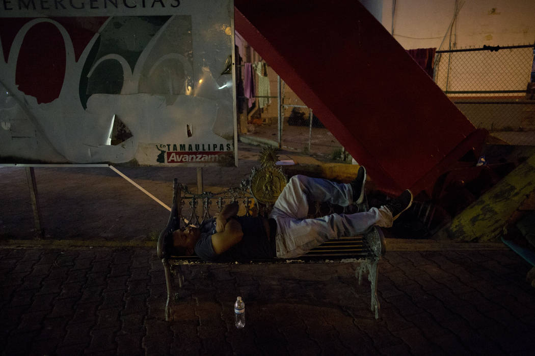 A migrant waiting to seek asylum sleeps at the entrance to the Puerta Mexico international brid ...