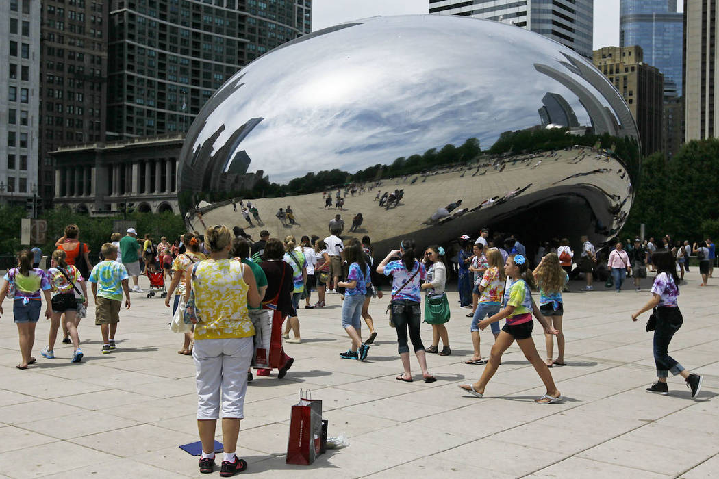 In this Wednesday, June 13, 2012, photo, visitors at Chicago's Millennium Park enjoy the sculpt ...