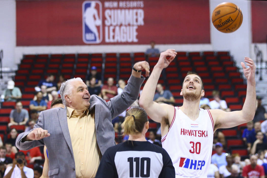 Gov. Steve Sisolak, left, participates in a tip off with Croatia's Antonio Vrankovic (30) befor ...