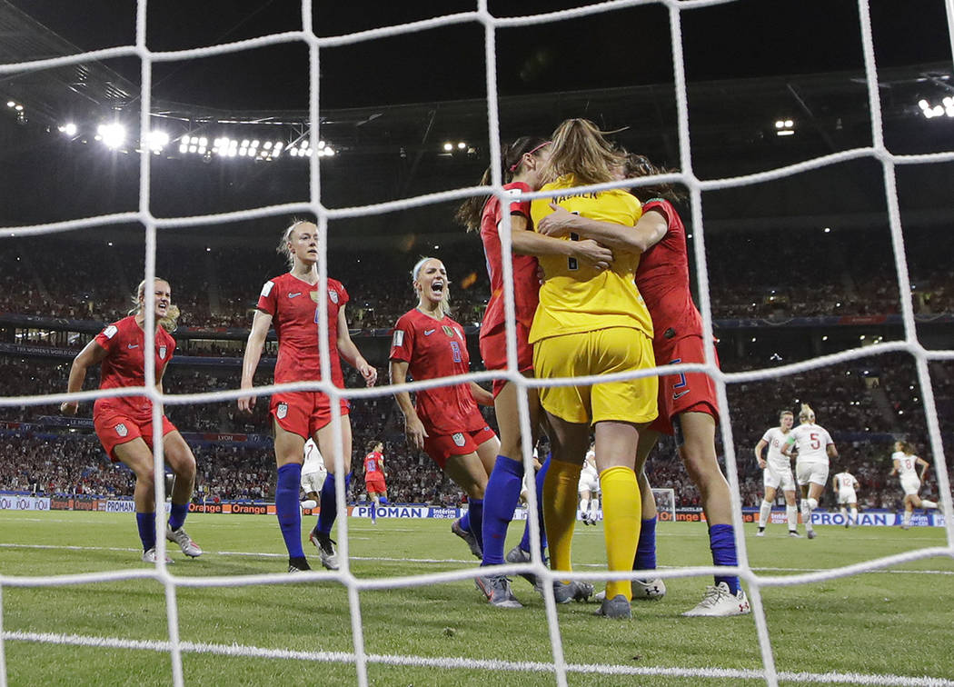 Team mates hug United States goalkeeper Alyssa Naeher after she saved a penalty shot taken by E ...