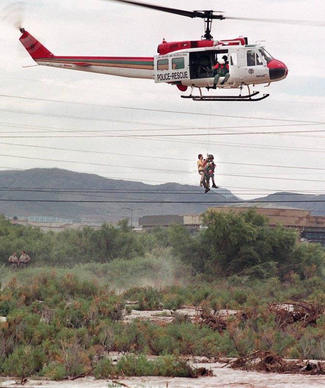 Las Vegas police rescue a man to safety after his vehicle was washed off Boulder Highway into F ...