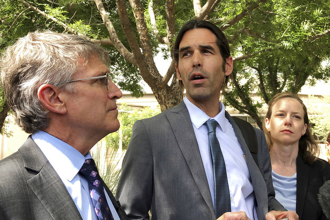 FILE - In this June 11, 2019 file photo Scott Warren, center, speaks outside federal court, in ...