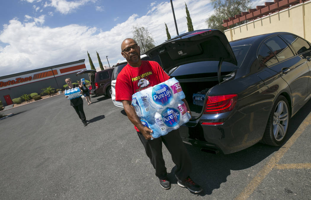 Las Vegas resident Randy Davis makes a water donation to Metro Pizza during a water bottle driv ...