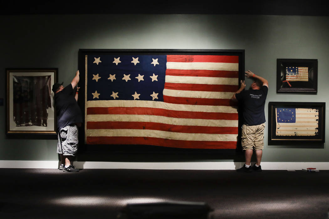 In this Wednesday, June 12, 2019 photo, workmen hang a Federal Era flag as part of the new exhi ...