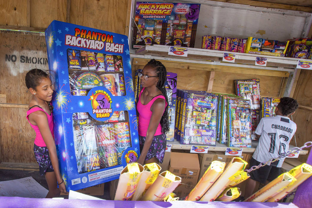 Ava Jordan, 11, left, and her sister Isaiah Jordan, right, 14, help move a box of fireworks whi ...