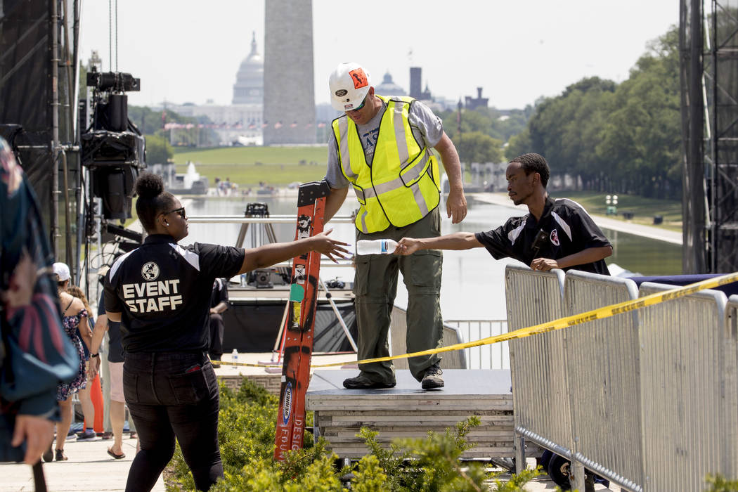 The Capitol Dome, the Washington Monument and the Reflecting Pool are visible as workers set up ...