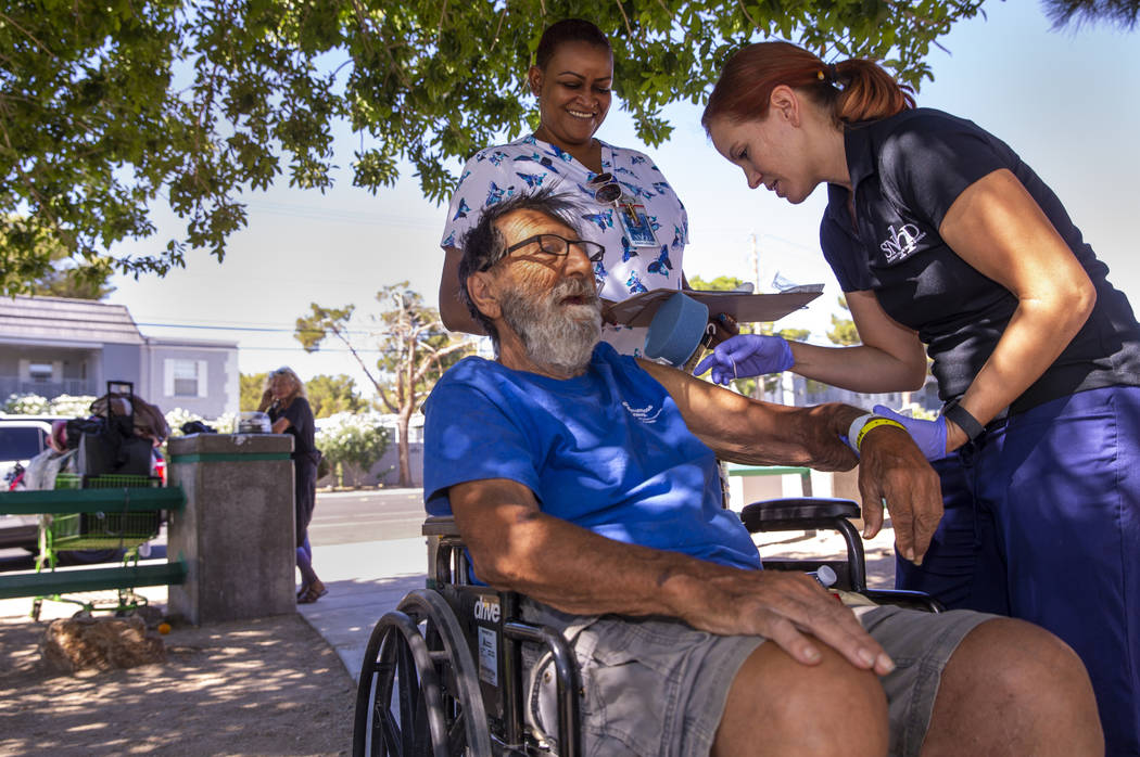 Homeless man Elias Sayegh, left, receives a Hepatitis A shot from Sarah Lugo, Southern Nevada H ...