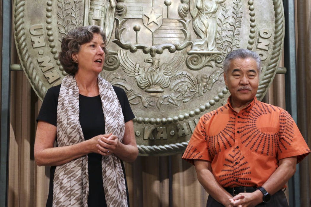 Hawaii Gov. David Ige, right, listens as Hawaii state Sen. Laura Thielen speaks before Ige sign ...