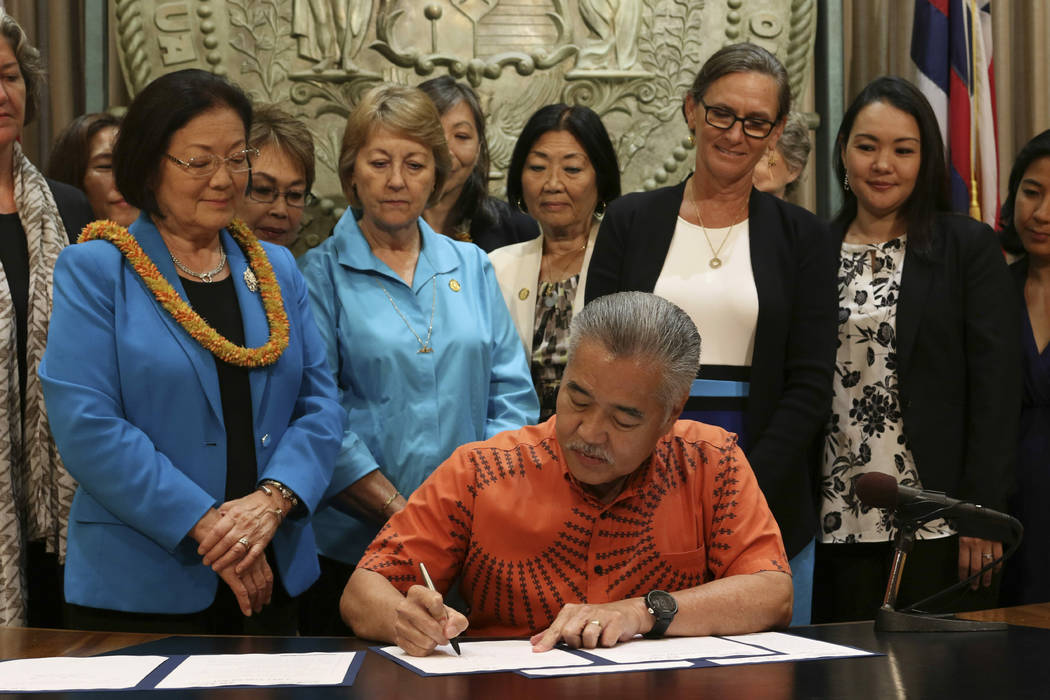 Hawaii Gov. David Ige, surrounded by members of the bipartisan Hawaii Women's Legislative Caucu ...