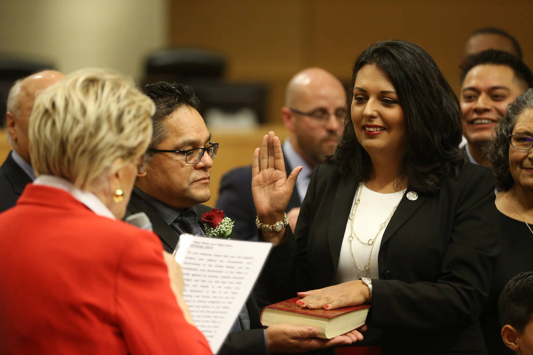 New Councilwoman Olivia Diaz, right, with her husband Frank, center, is sworn into office by Ma ...