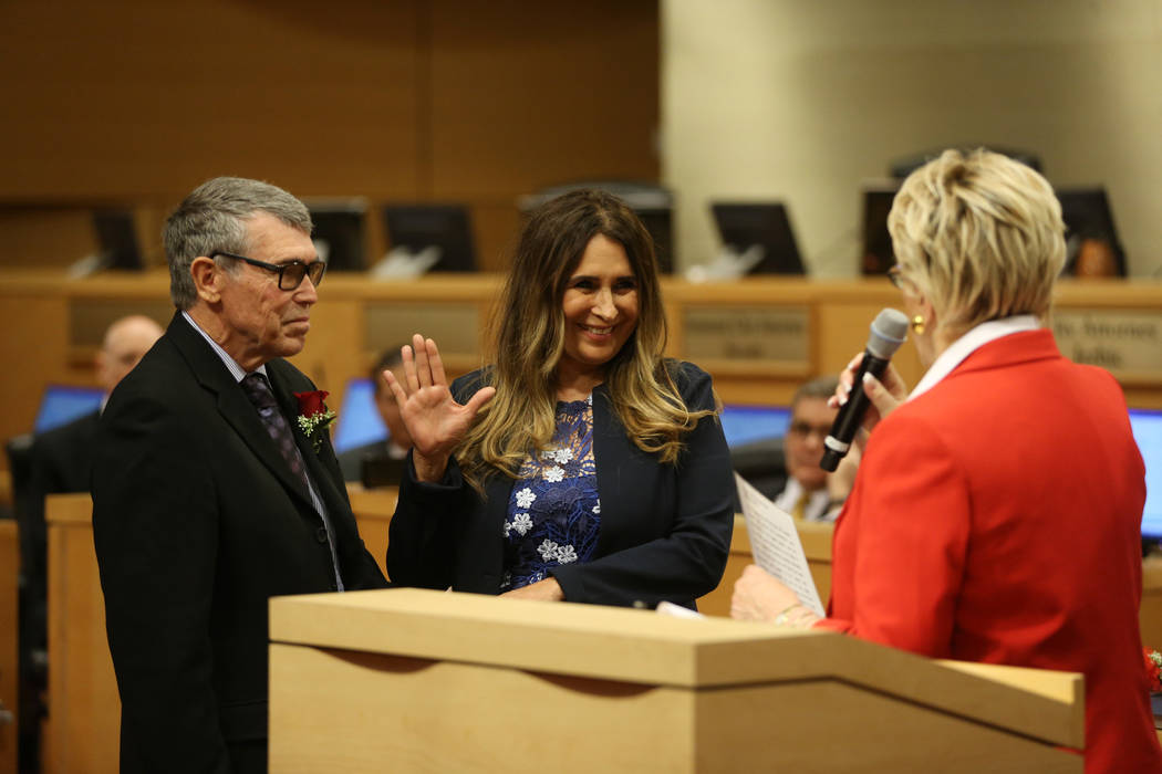 New Councilwoman Victoria Seaman, center, with her husband John Seaman, left, is sworn into off ...