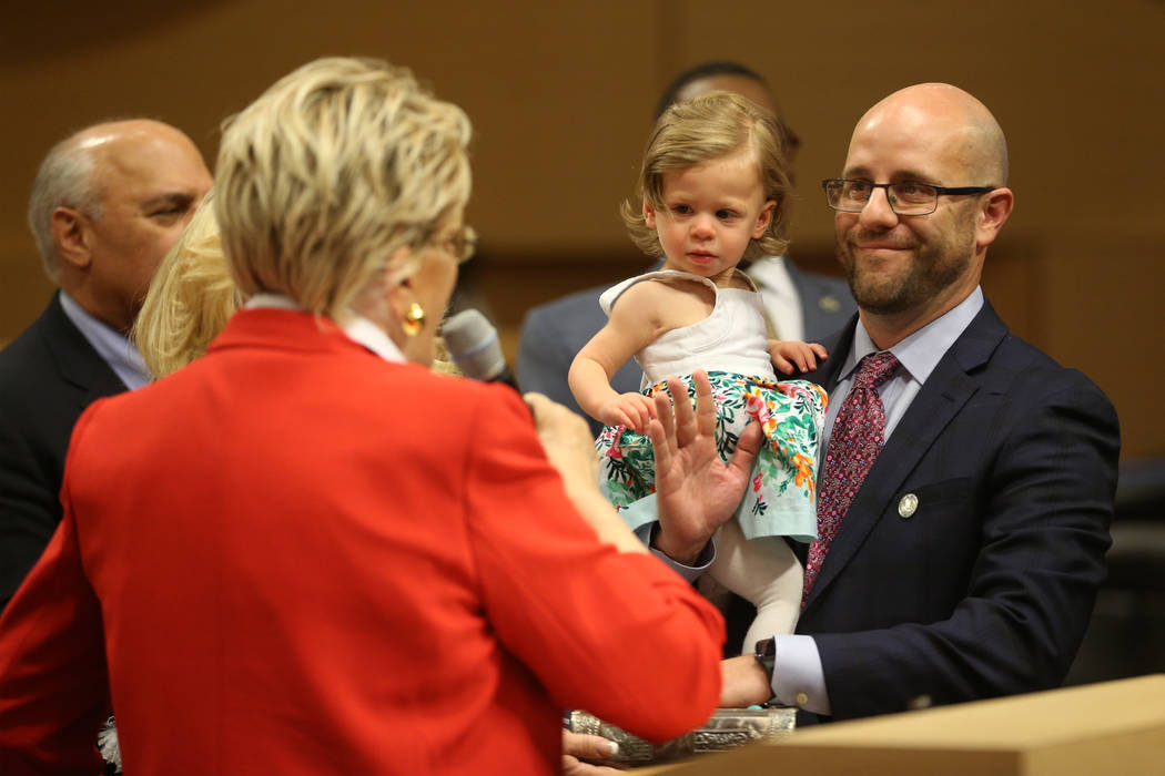 New Councilman Brian Knudsen, right, holding his daughter Kate, 1, is sworn into office by Mayo ...