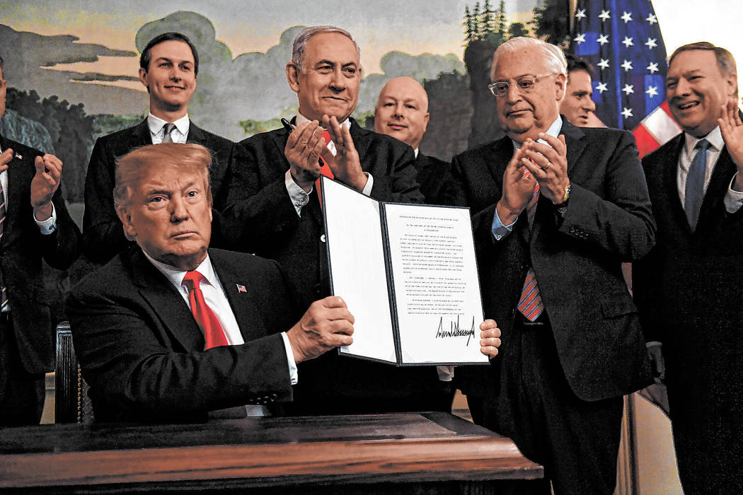 President Donald Trump holds up a signed proclamation recognizing Israel's sovereignty over the ...