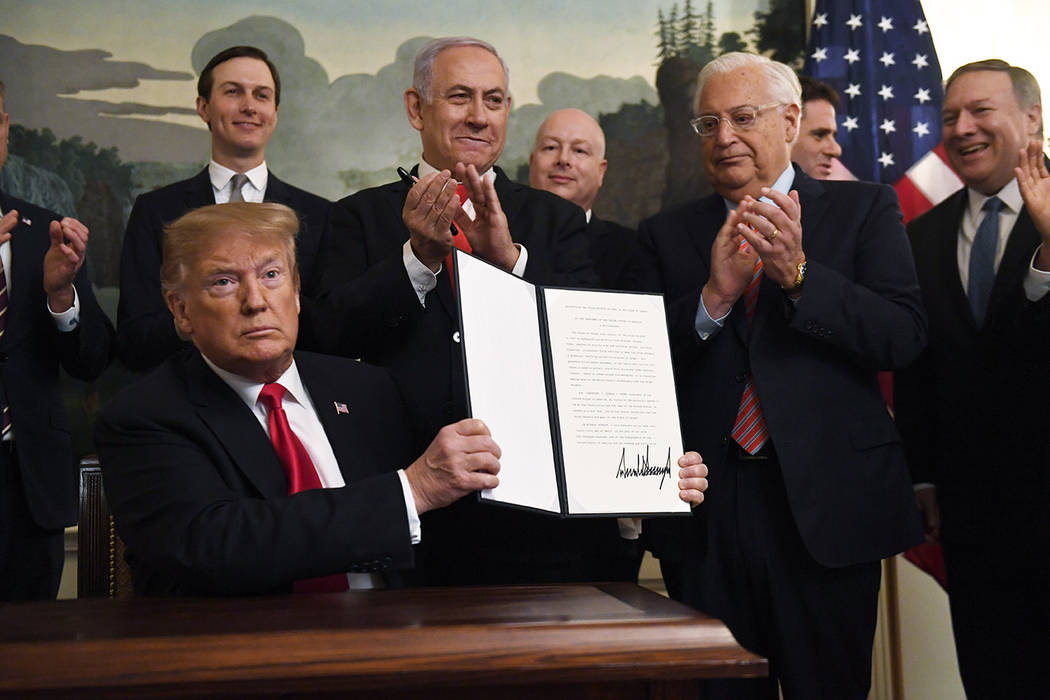 President Donald Trump holds up a signed proclamation recognizing Israel's sovereignty over the ...