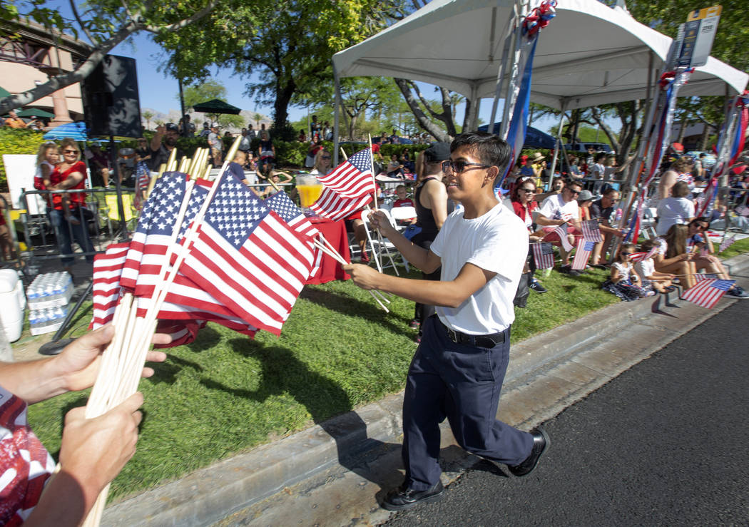 Angel Lemurs, 16, hands out American flags during the 25th annual Summerlin Council Patriotic P ...