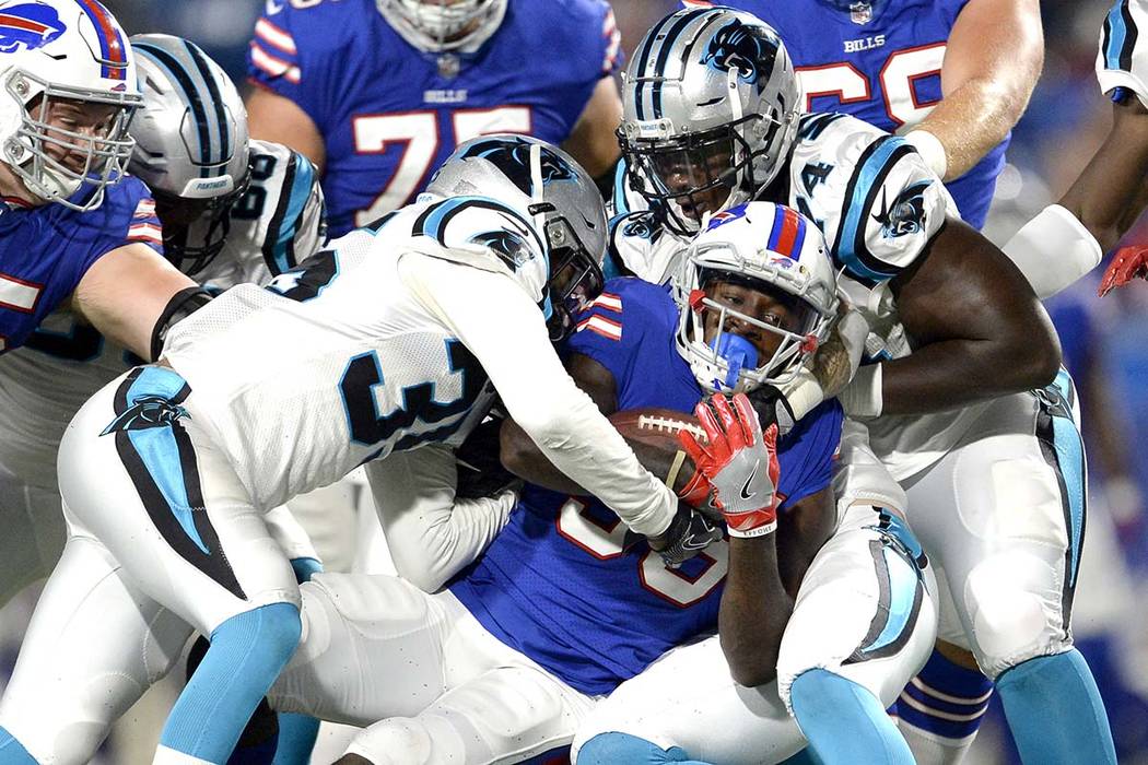 Buffalo Bills running back Keith Ford, center, is tackled by Carolina Panthers cornerback Corn ...