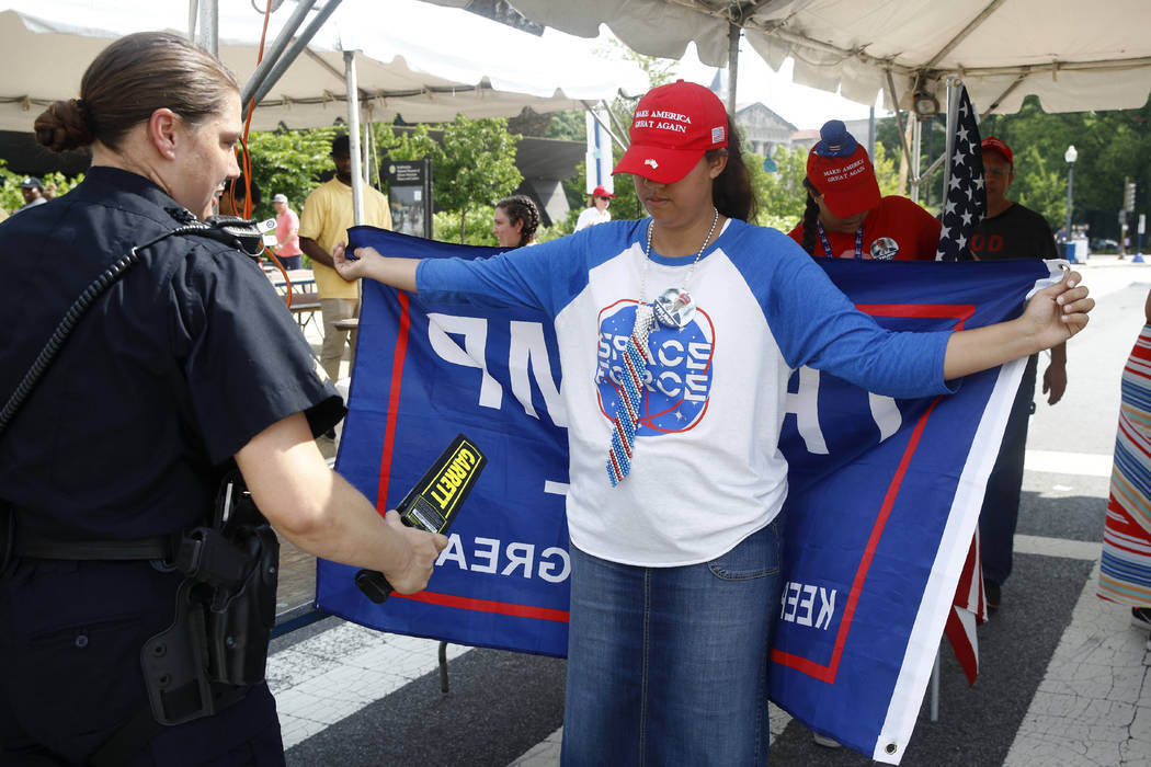 A supporter of President Donald Trump makes her way through a security checkpoint before Indepe ...