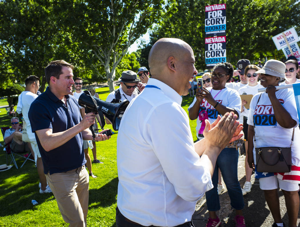 Rep. Seth Moulton, D-Mass., left, talks as Democratic presidential candidate Sen. Cory Booker, ...