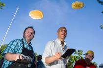 Nevada Treasurer Zach Conine, left, flips pancakes with Democratic presidential candidate Sen. ...