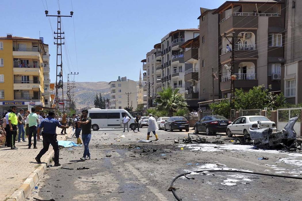 Security and forensic officials work at the site after an explosion inside a vehicle in Reyhanl ...